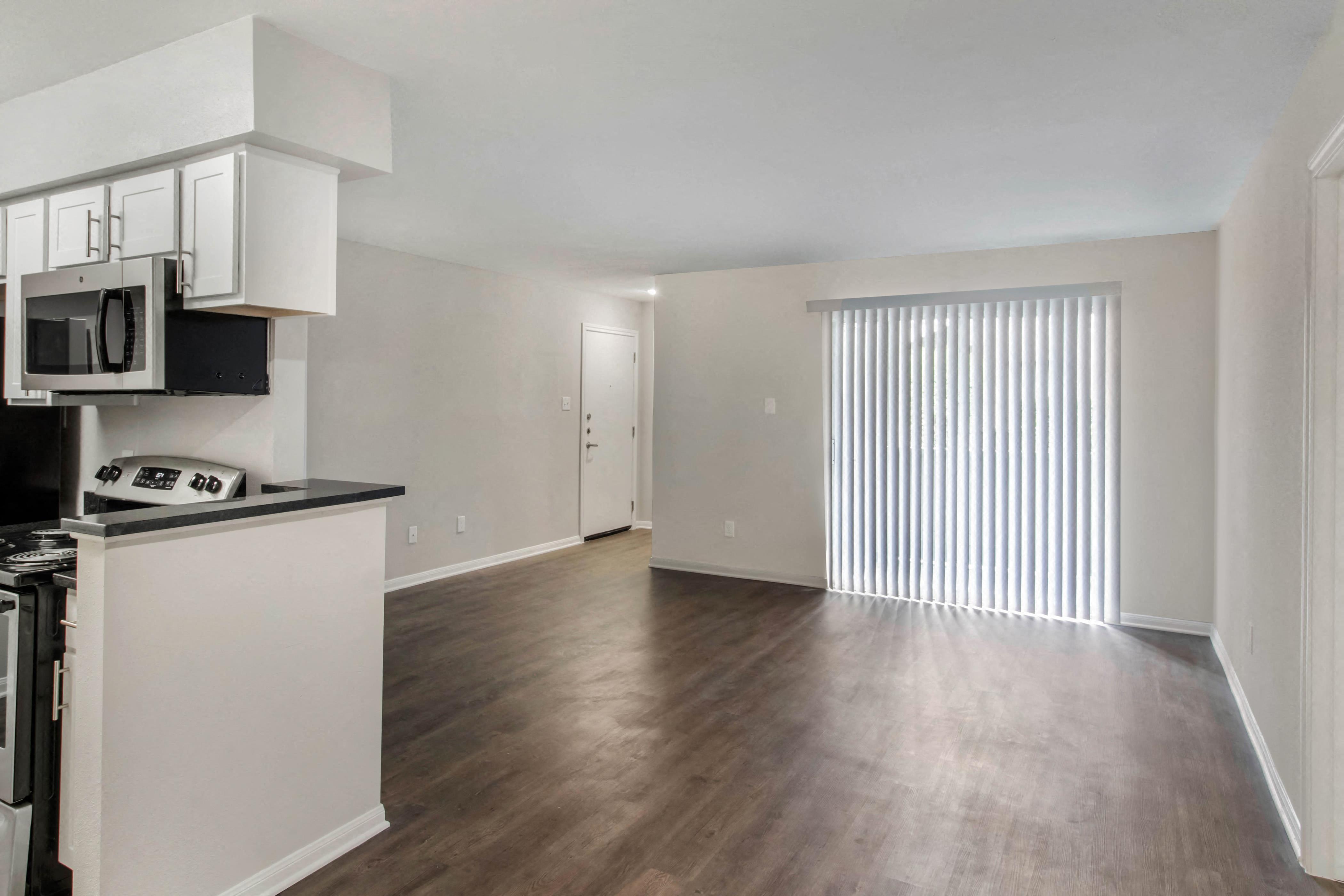 A kitchen with white cabinets and a black countertop.