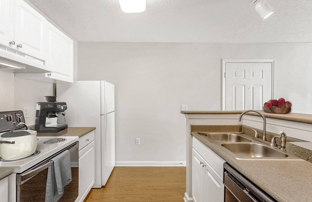 A kitchen with white cabinets and a stove top oven. at The Grayson Apartment Homes, North Carolina