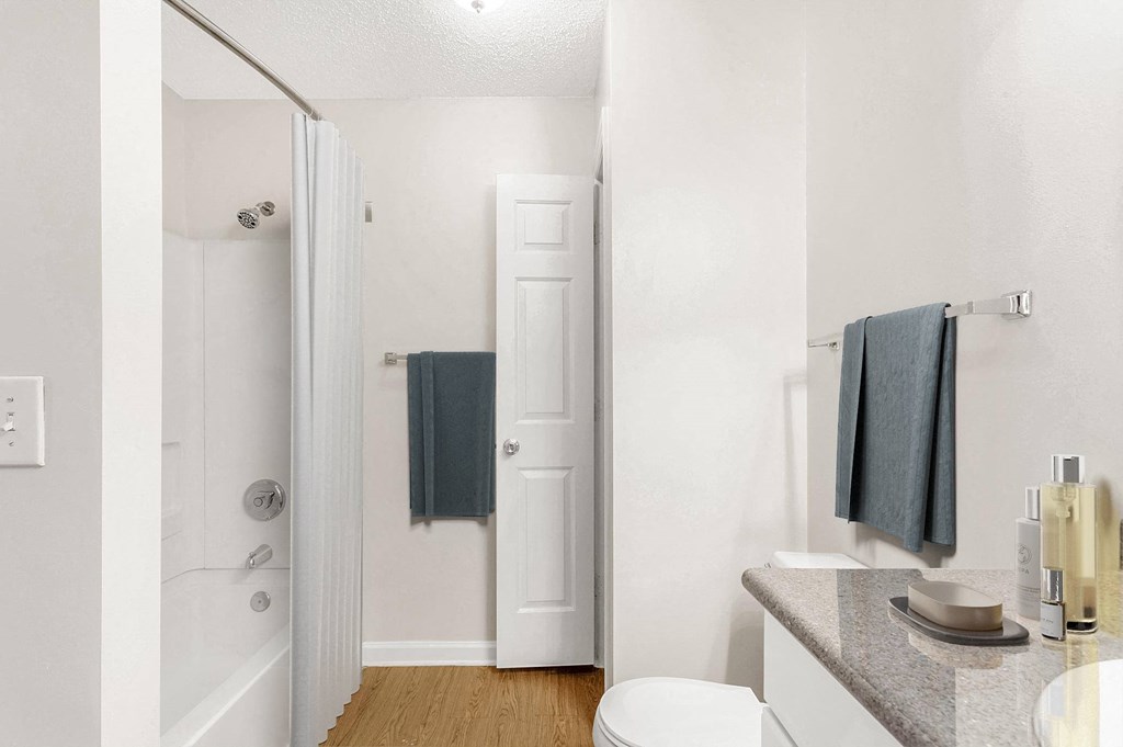A white bathroom with a toilet, sink, and bathtub. at The Grayson Apartment Homes, Charlotte