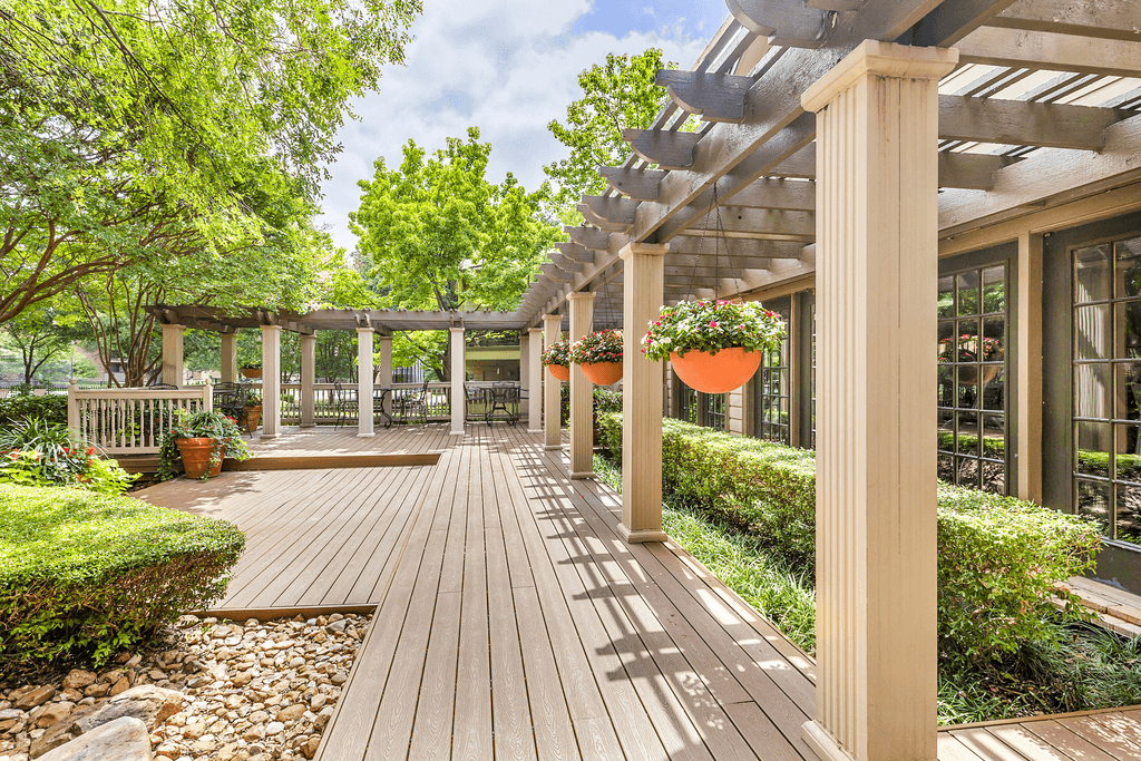 Clubhouse exterior patio with pergola, wrought iron tables and chairs with native landscape