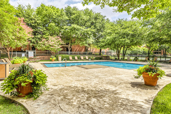 Swimming pool with lounge chairs, picnic table and native landscape