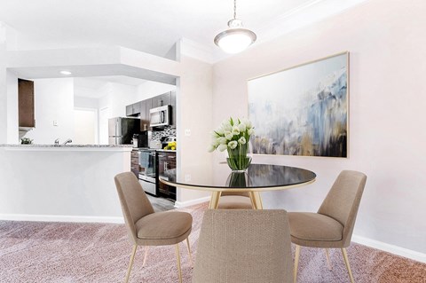 A modern dining room with a glass table and chairs at Elan at Mallard Creek Apartment Homes, Charlotte, North Carolina