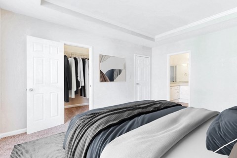 A bedroom with a bed, a wardrobe, and a mirror at Elan at Mallard Creek Apartment Homes, Charlotte, NC
