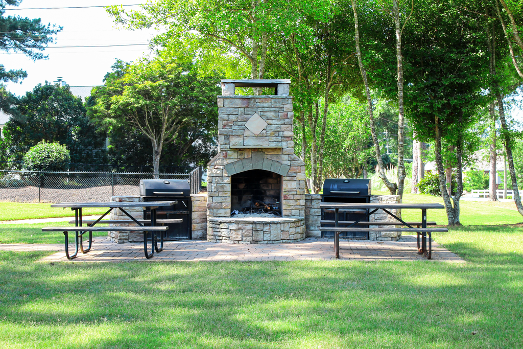outdoor fireplace with grilling stations and picnic tables