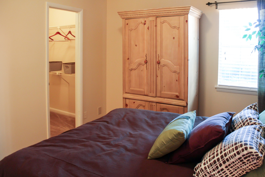 furnished bedroom with closet and window