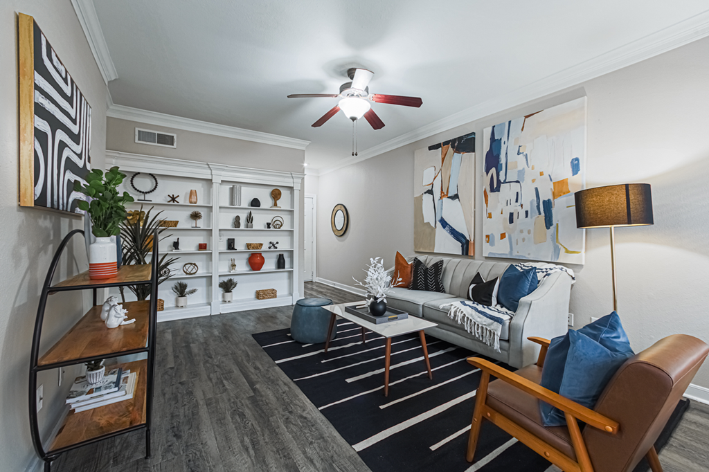 staged living room with hardwood-style flooring and ceiling fan