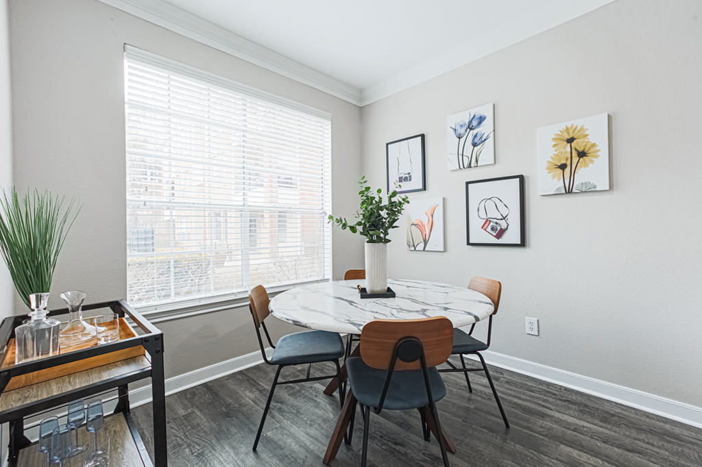 a dining room with a table and hardwood-style flooring