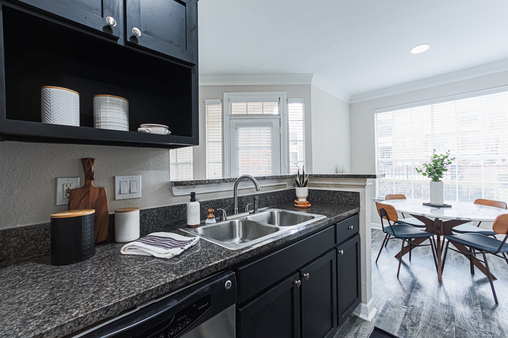 kitchen with black cabinetry and granite-style countertops