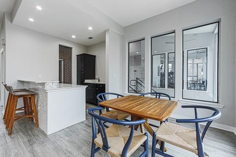 a dining area with a table and chairs and a kitchen with a counter