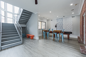 clubhouse lounge with a table and a staircase