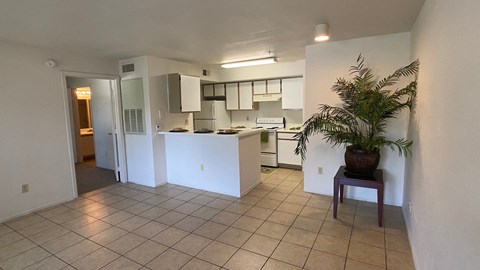 A kitchen with white cabinets and a tiled floor.