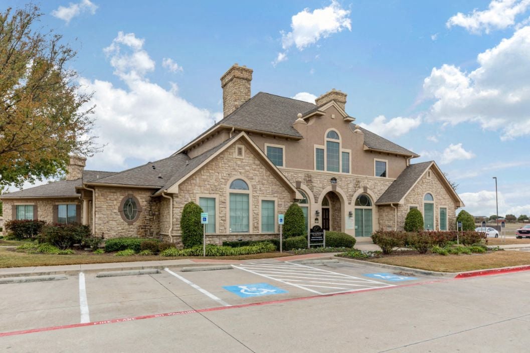 A large house with a stone facade and a chimney.
