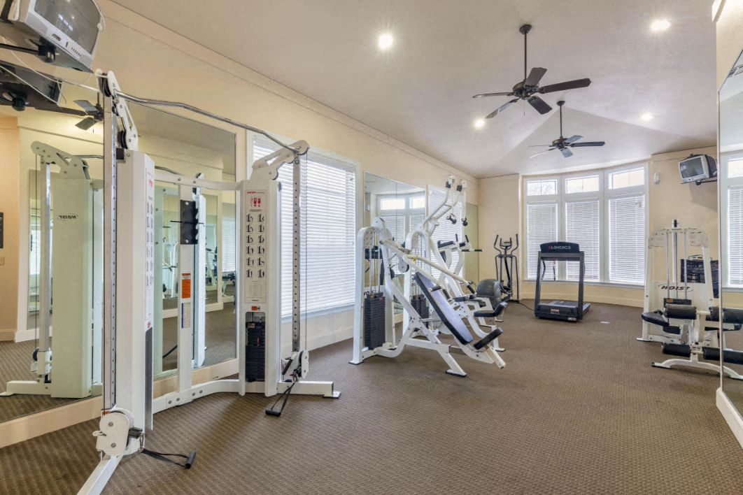 Fitness Center with a treadmill, free weights, ceiling fans, and large spacious windows