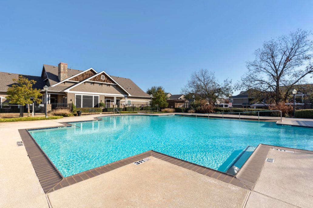 A large swimming pool in front of a house.
