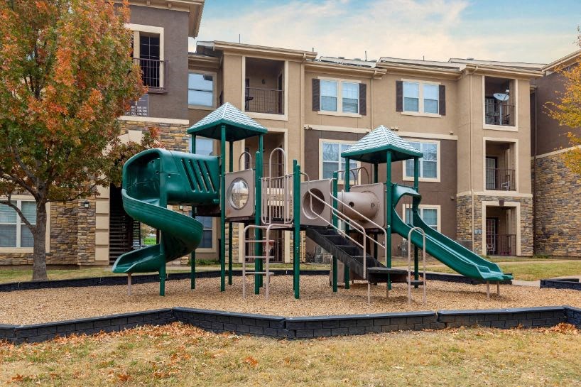 Green playground with building exterior in the background