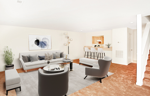A living room with a grey sofa, a grey armchair, a grey coffee table and a grey rug.