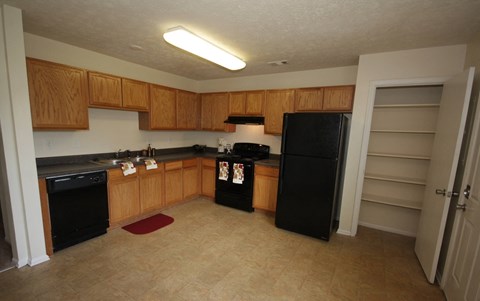 A kitchen with black appliances and wooden cabinets.