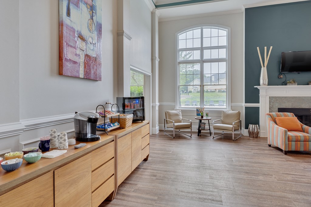 A living room with a fireplace and a painting on the wall.