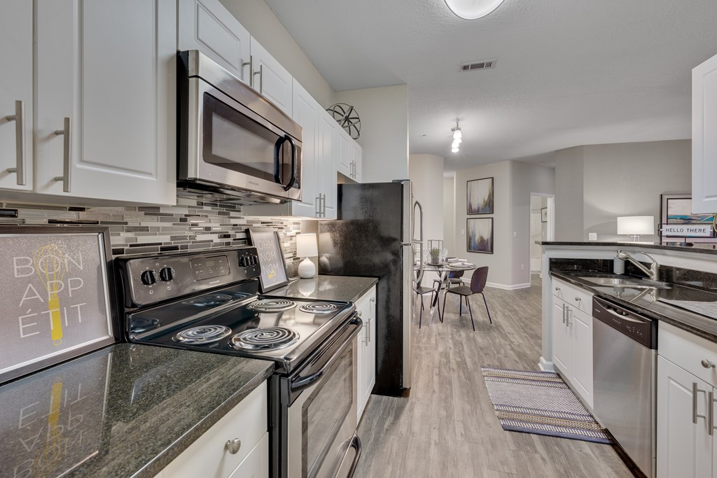 A kitchen with a black stove top oven and a black refrigerator.