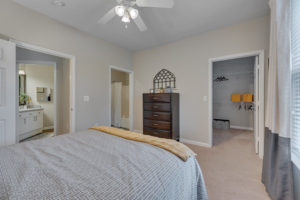 A bedroom with a bed, dresser, and mirror.