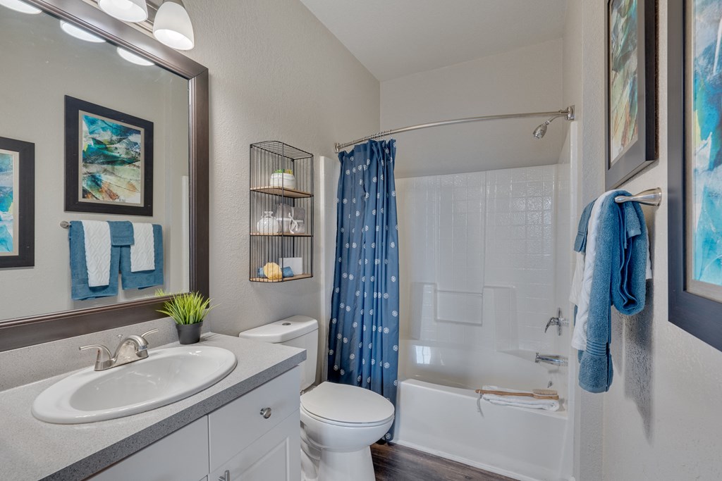 A bathroom with a white toilet, sink, and shower.