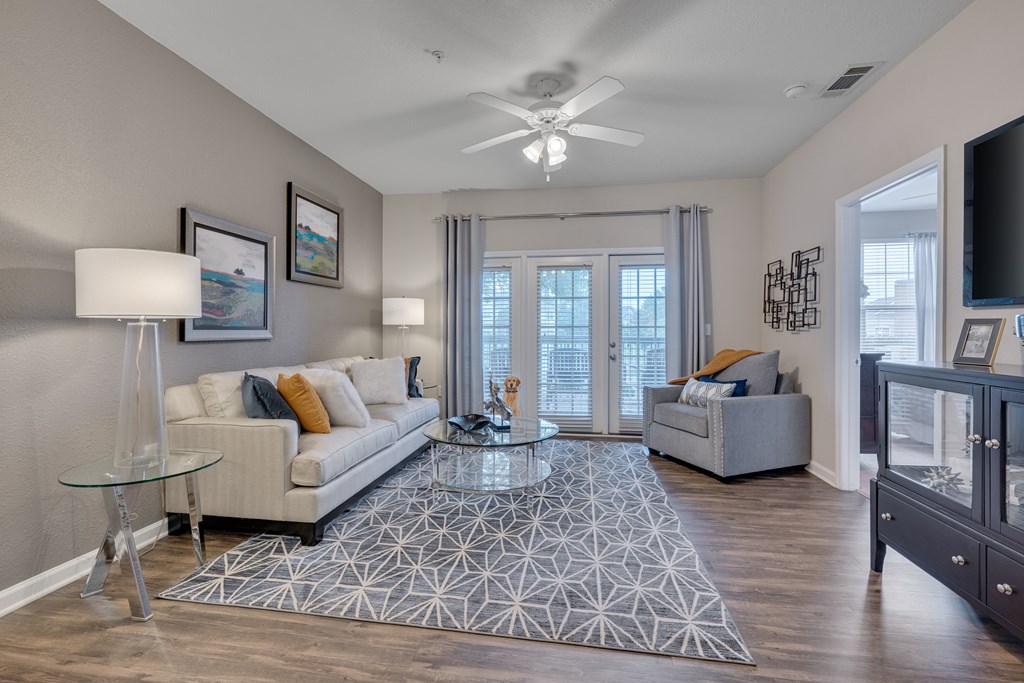 A living room with a glass table and a white couch.