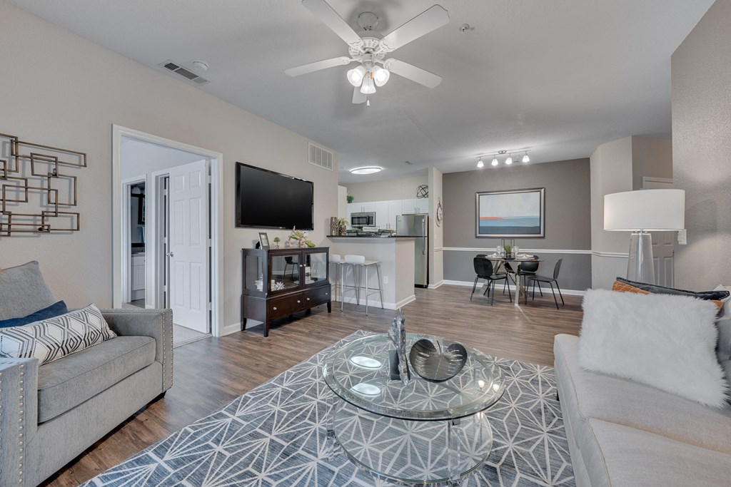 A modern living room with a glass coffee table in the center.