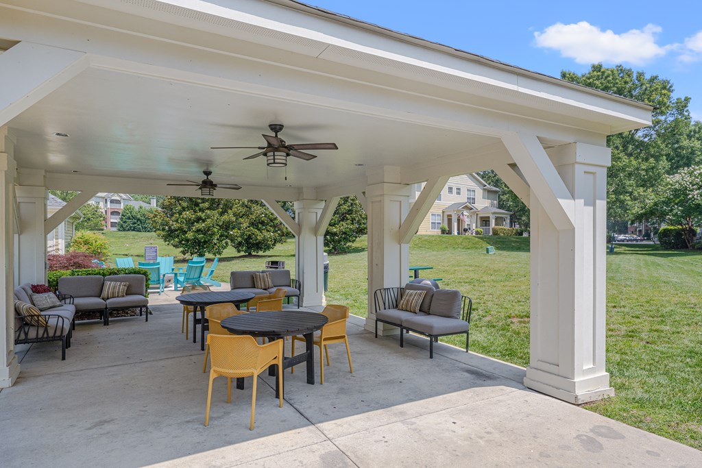 A covered patio with a table and chairs.