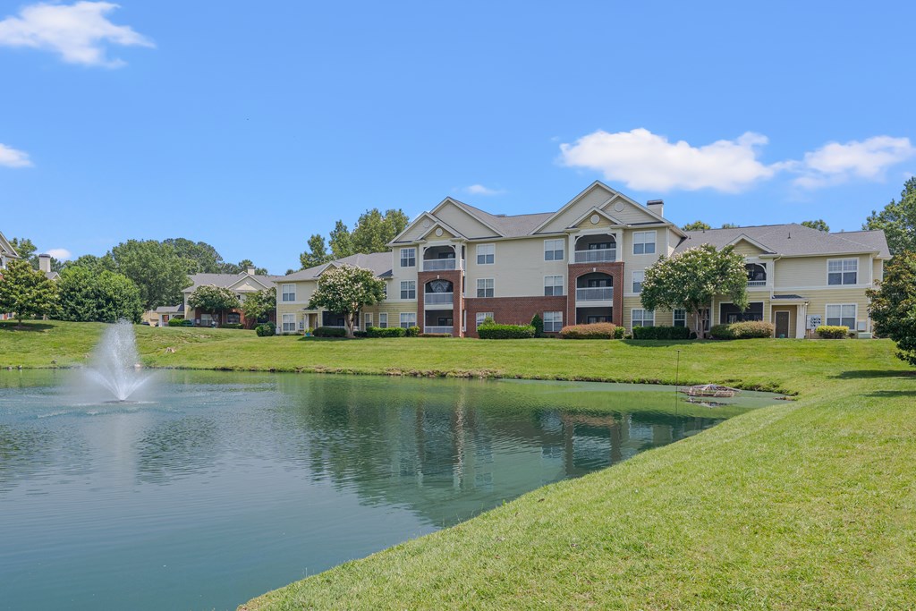 An apartment buildiong with a fountain in front of it.