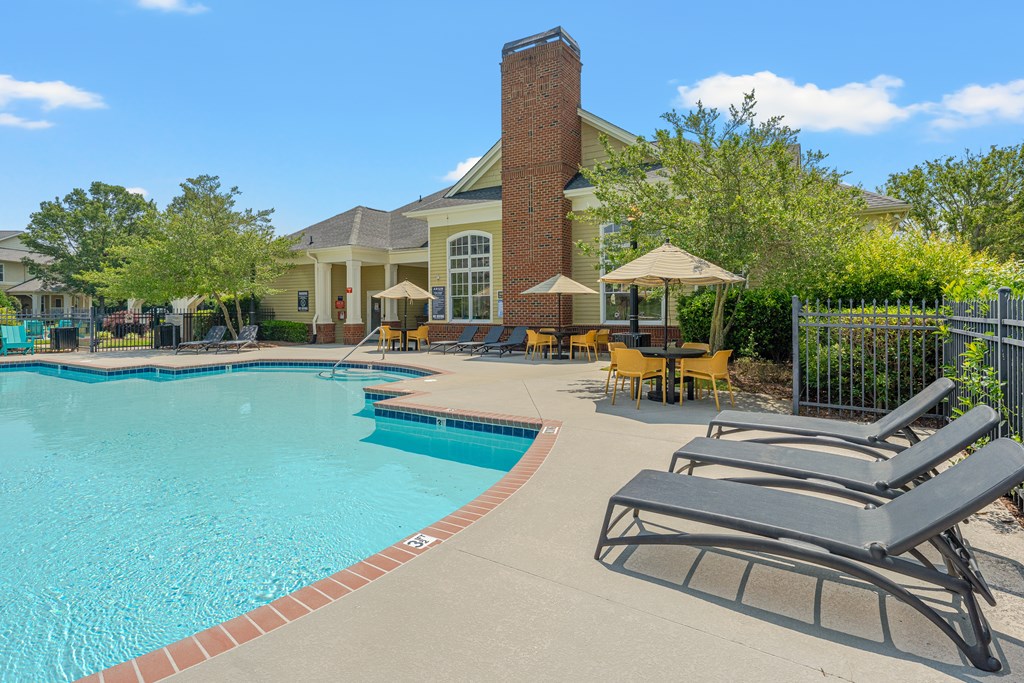 A pool with a red brick chimney behind it.