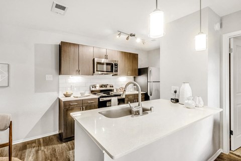 A kitchen with a white counter top and wooden cabinets.