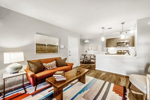 A living room with a red couch and a wooden coffee table.