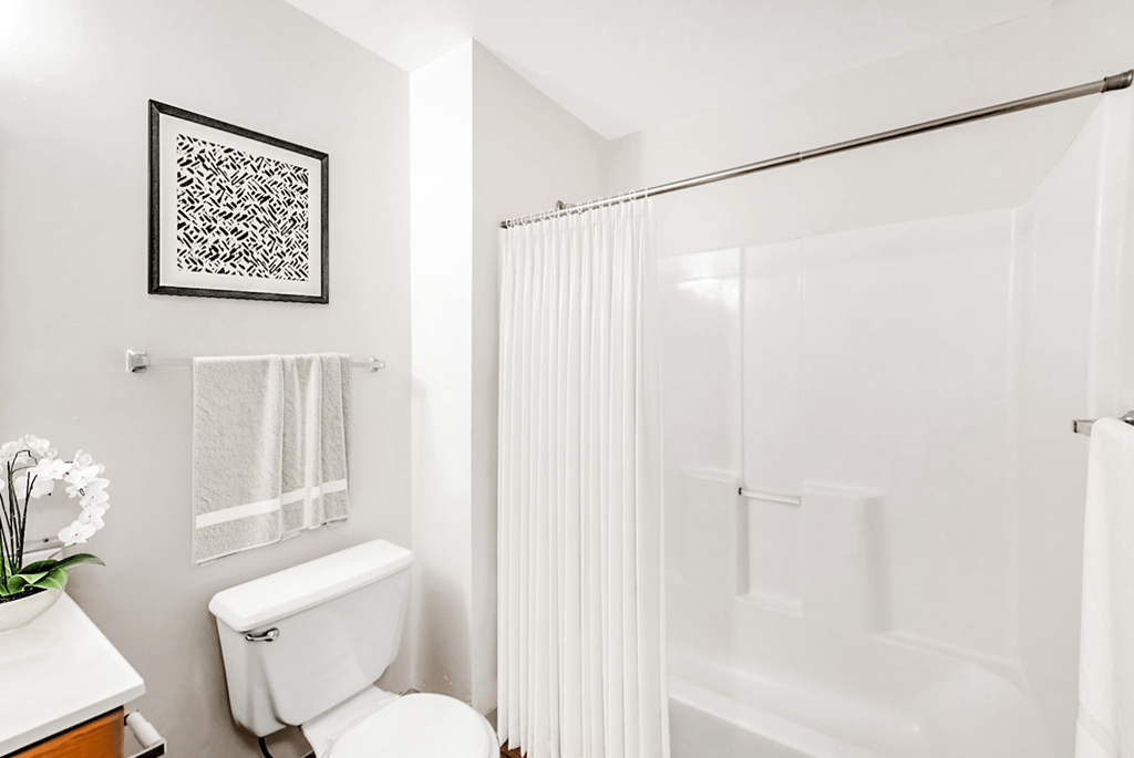 a bathroom with a white toilet and a white shower curtain