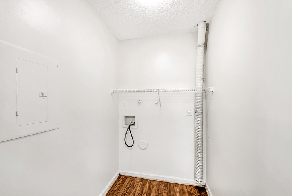 a bathroom with white walls and wood flooring