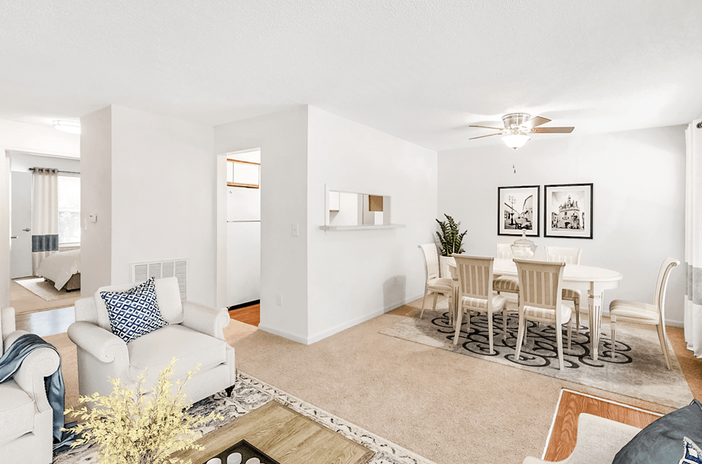 a living room and dining room with a couch and chair and a table with chairs
