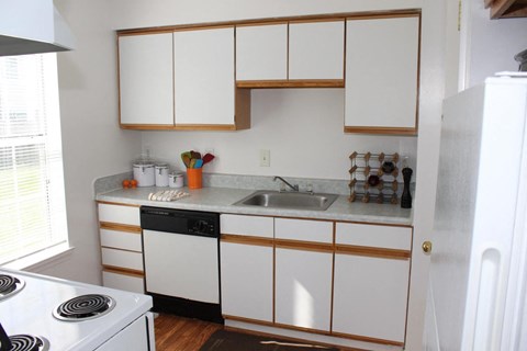 a small kitchen with white cabinets and a sink