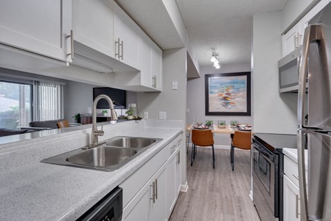 A modern kitchen with a stainless steel sink and refrigerator.