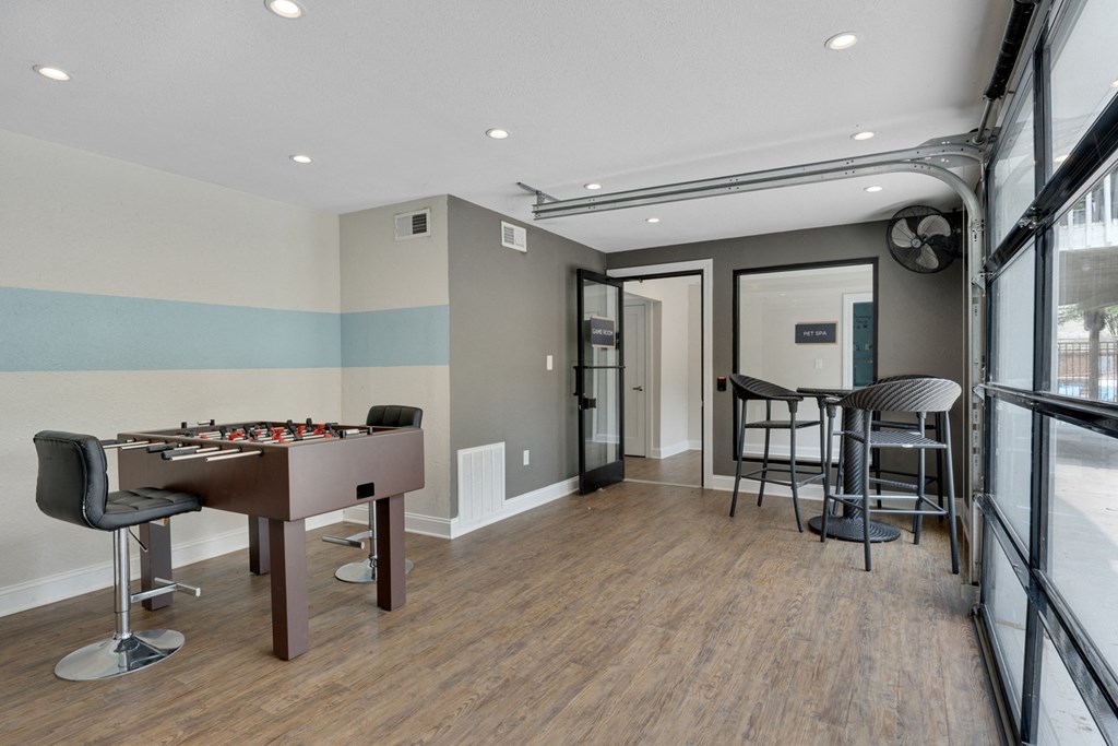game room with a pool table and a bar area.