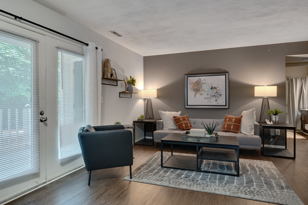 A living room with a grey sofa, a blue armchair, and a coffee table.