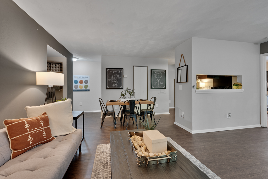A living room with a grey couch and a wooden coffee table.
