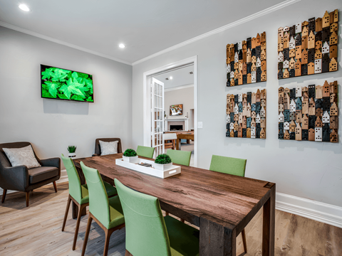 a dining room with a wooden table and green chairs