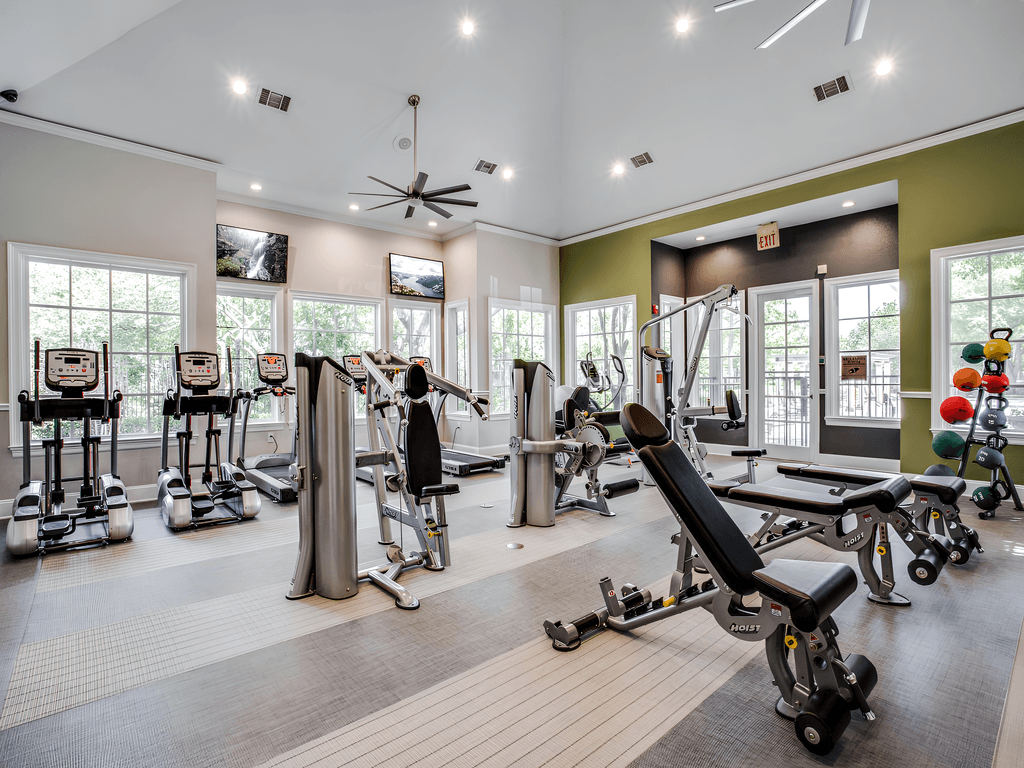 a gym with a lot of exercise equipment and windows