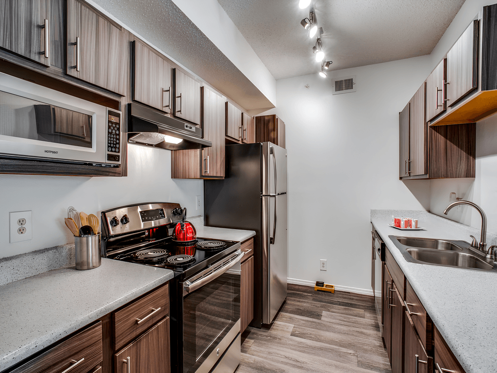 private kitchen with stainless steel appliances and white countertops in a rental home