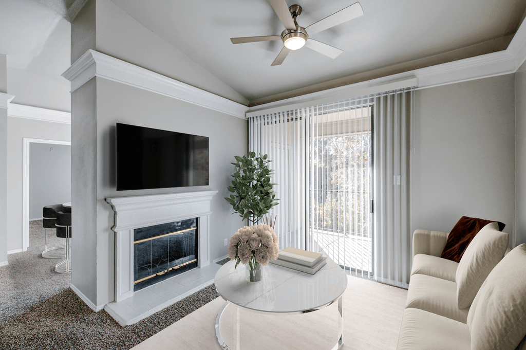 a living room with a fireplace and a ceiling fan