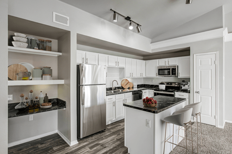 a kitchen with white cabinets and stainless steel appliances
