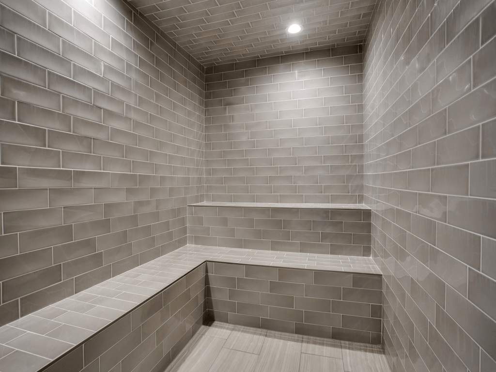 a small bathroom with tiled walls and a wood floor