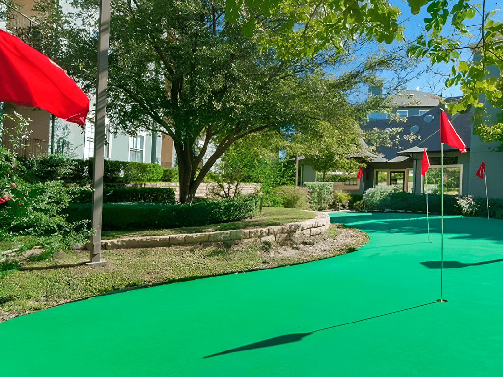a green golf course in front of a house