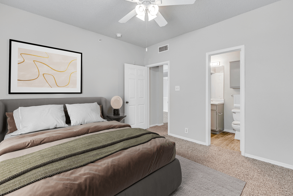 a bedroom with a large bed and a ceiling fan