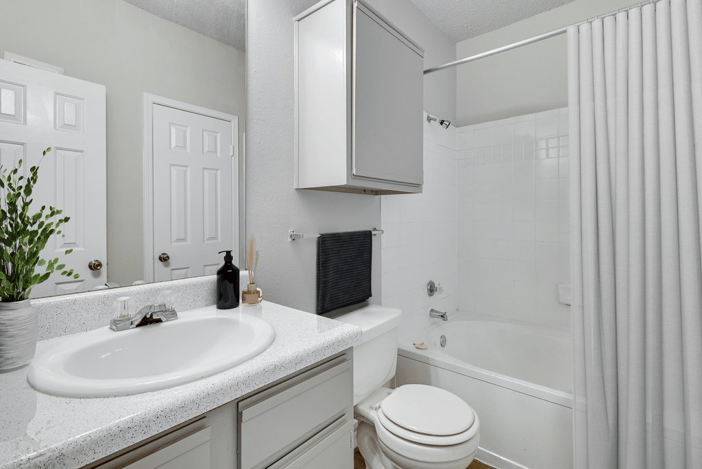 a white bathroom with a sink toilet and shower