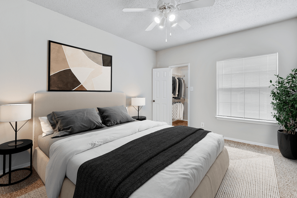 a bedroom with a large bed and a ceiling fan